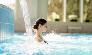 Ragazza che è immersa nella piscina termale a 30 gradi